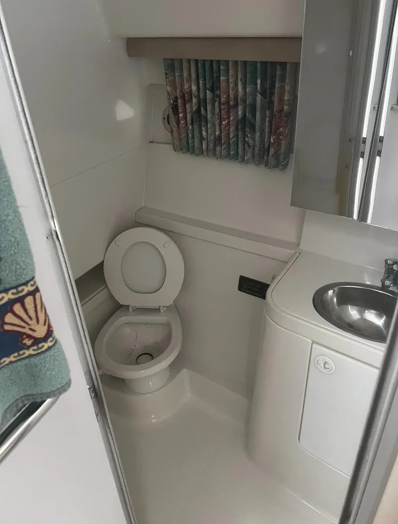 Slide: The Image of 1997 Formula 34 PC boat bathroom with toilet, sink, and window. - 14
