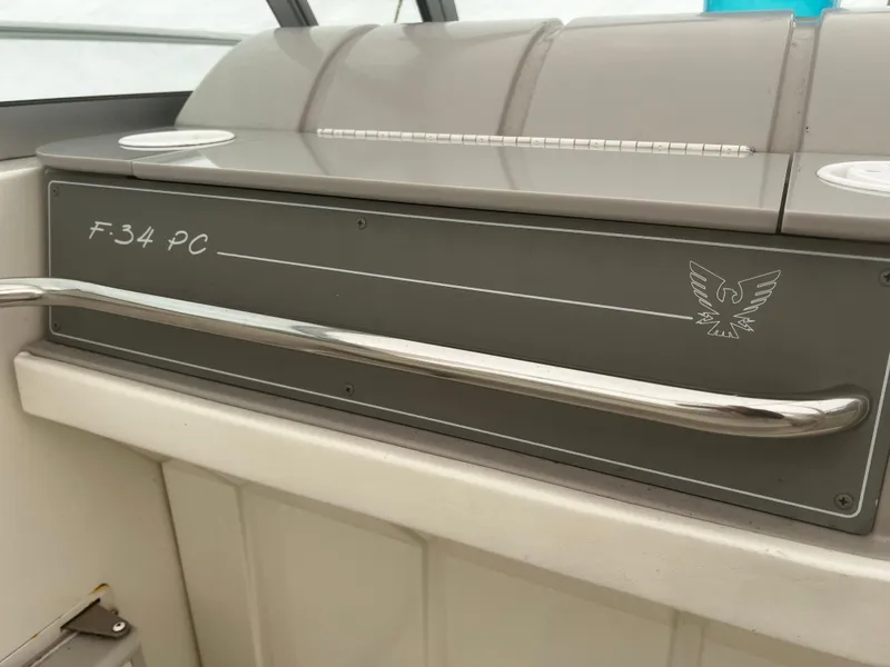 Slide: The Image of 1997 Formula 34 PC boat interior with white and teal cushioned seating. - 7