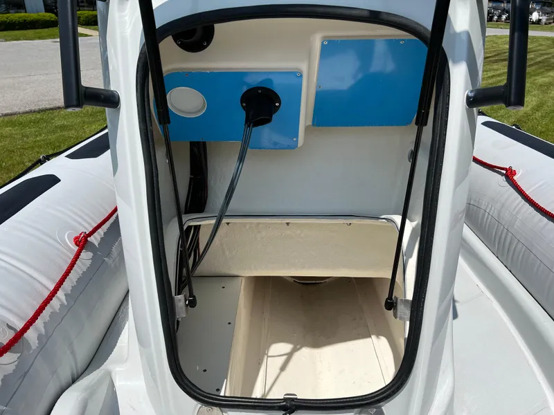 Slide: The Image of 2023 Zodiac Open 5.5 boat interior with control panel and storage area. - 11