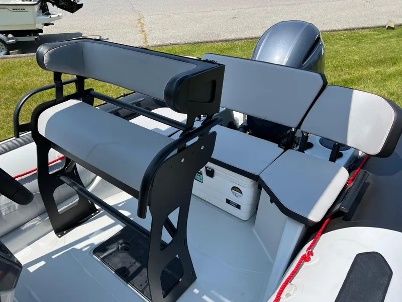 Slide: The Image of 2023 Zodiac Open 5.5 boat interior with seating and motor. - 7