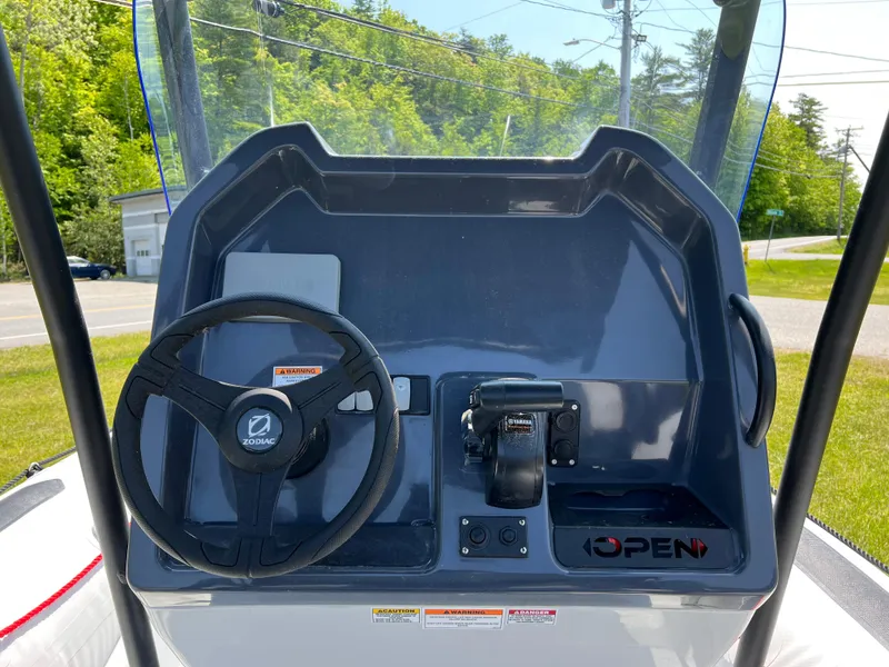 Slide: The Image of 2023 Zodiac Open 5.5 boat dashboard with steering wheel and controls. - 8
