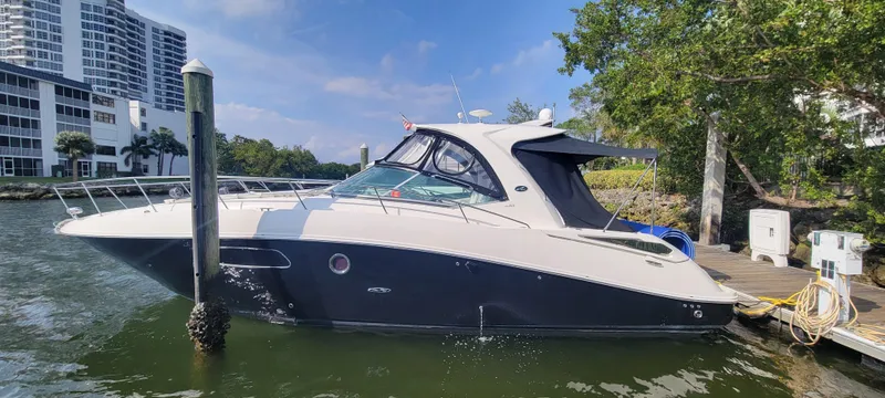 Slide: The Image of 2008 Sea Ray 350 Sundancer docked at marina with modern buildings in background. - 2