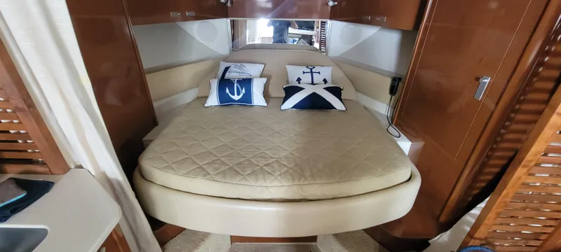 Slide: The Image of 2008 Sea Ray 350 Sundancer cabin with bed and nautical-themed pillows. - 21
