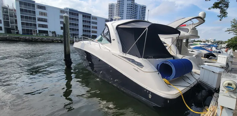 Slide: The Image of 2008 Sea Ray 350 Sundancer docked at a marina with modern buildings in the background. - 4