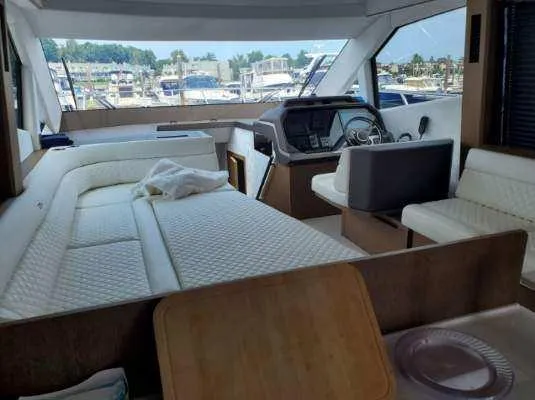Slide: The Image of Interior of 2020 Galeon 500 Fly yacht with white seating and helm station. - 7