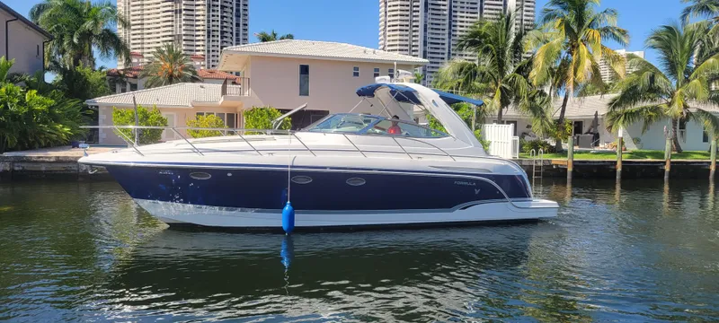 Slide: The Image of 2006 Formula 34 PC yacht docked near waterfront homes and palm trees. - 13