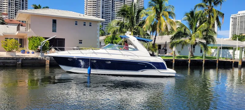 Slide: The Image of 2006 Formula 34 PC yacht docked by waterfront homes with palm trees. - 2