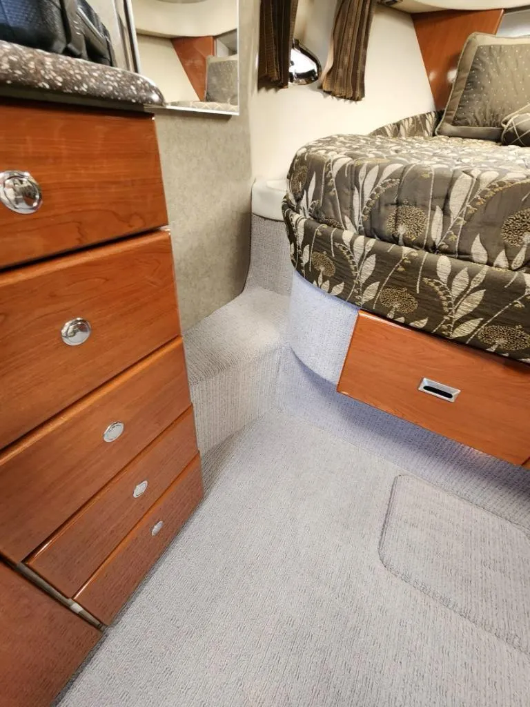 Slide: The Image of Interior cabin of a 2006 Formula 34 PC boat with wooden drawers and a patterned bedspread. - 30