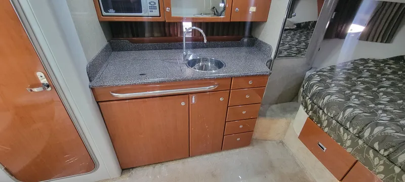 Slide: The Image of 2006 Formula 34 PC interior kitchen with sink, microwave, and storage cabinets. - 36