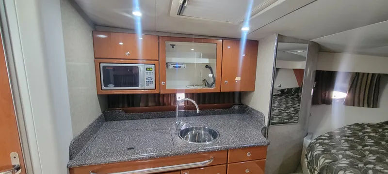 Slide: The Image of 2006 Formula 34 PC yacht interior kitchen with microwave, sink, and cabinets. - 38