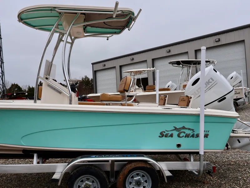 Slide: The Image of 2024 Sea Chaser 21 LX boat on a trailer, teal hull, parked outdoors. - 8