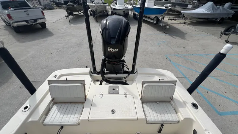 Slide: The Image of 2012 Frontier 2104 boat with 200 HP engine, rear seating, and storage compartments. - 13