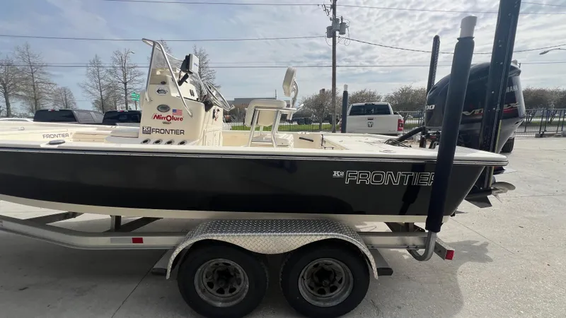 Slide: The Image of 2012 Frontier 2104 boat on a dual-axle trailer in a parking lot. - 7