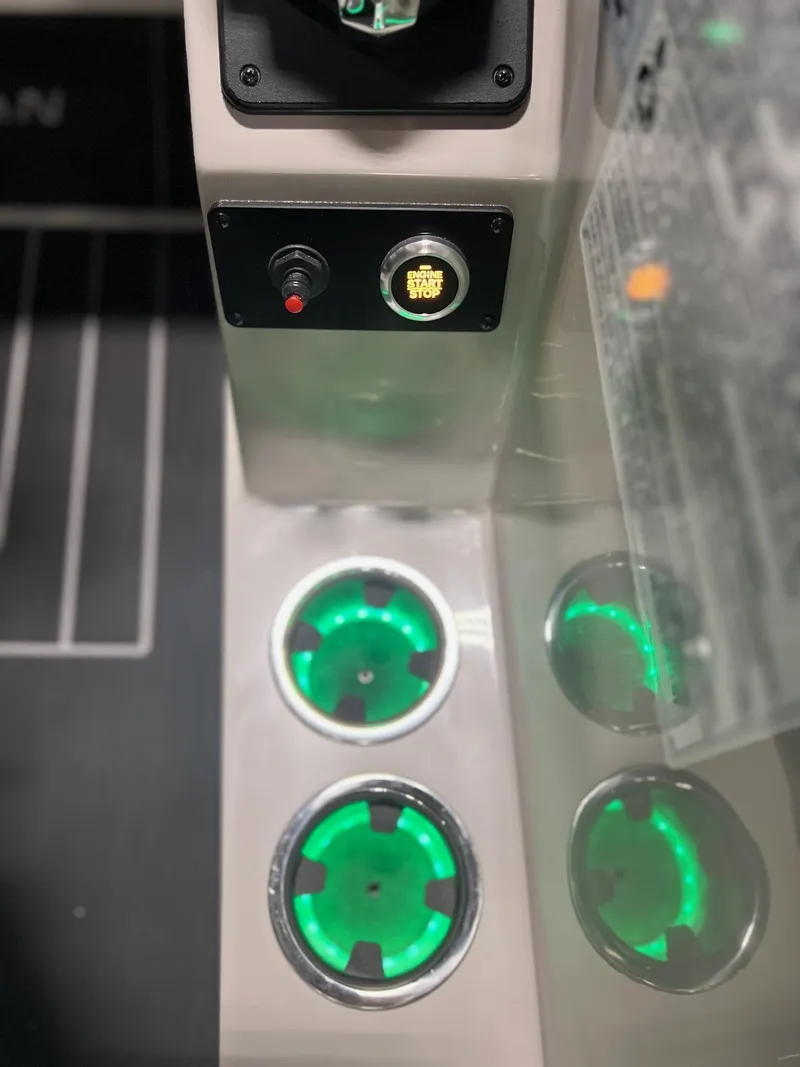 Slide: The Image of 2024 Sylvan G5 CLZ DC Arch Tritoon dashboard with illuminated cup holders and engine start/stop button. - 30