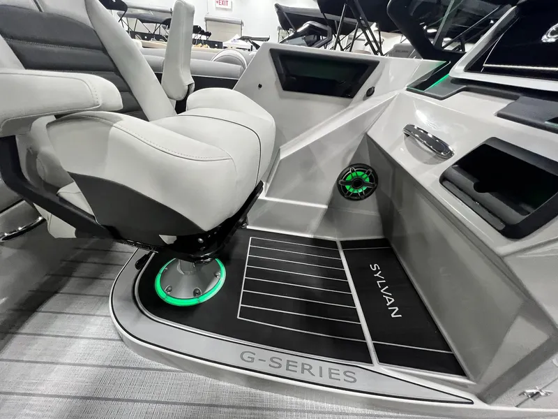 Slide: The Image of 2024 Sylvan G5 CLZ DC Arch Tritoon interior with illuminated captain's chair and modern dashboard. - 31