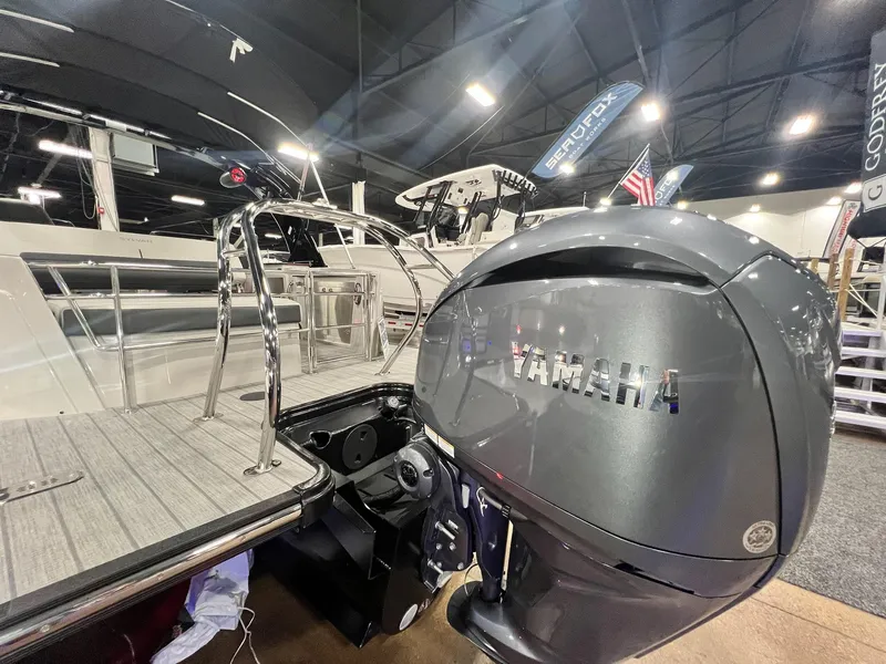 Slide: The Image of 2024 Sylvan G5 CLZ DC Arch Tritoon with Yamaha outboard motor at a boat show. - 7