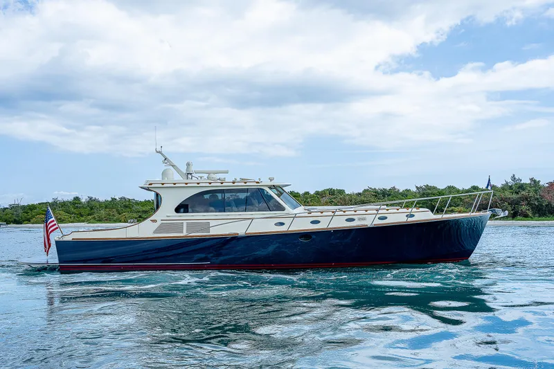 Slide: The Image of 2018 Hinckley Talaria 55 MKII MY yacht cruising on calm waters under a cloudy sky. - 1