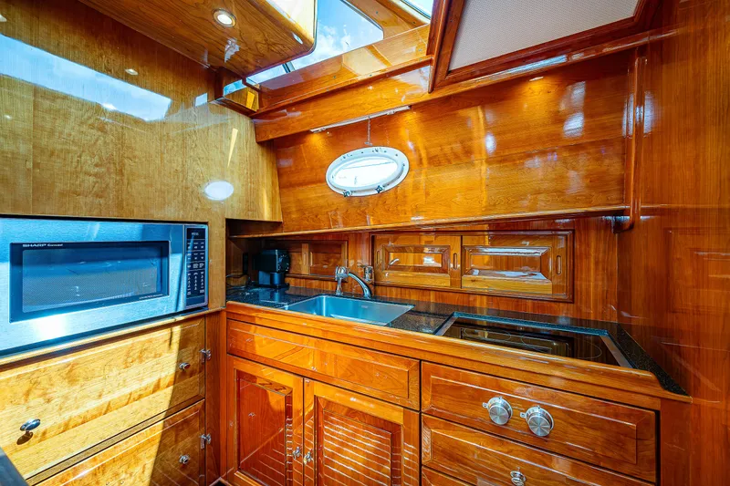 Slide: The Image of Luxurious 2018 Hinckley Talaria 55 MKII MY yacht kitchen with wood finish and modern appliances. - 36