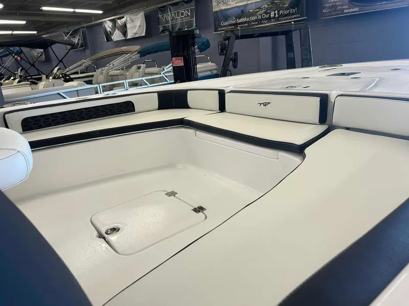Slide: The Image of 2024 Tidewater 2300 Carolina Bay boat interior with cushioned seating and storage compartment. - 6
