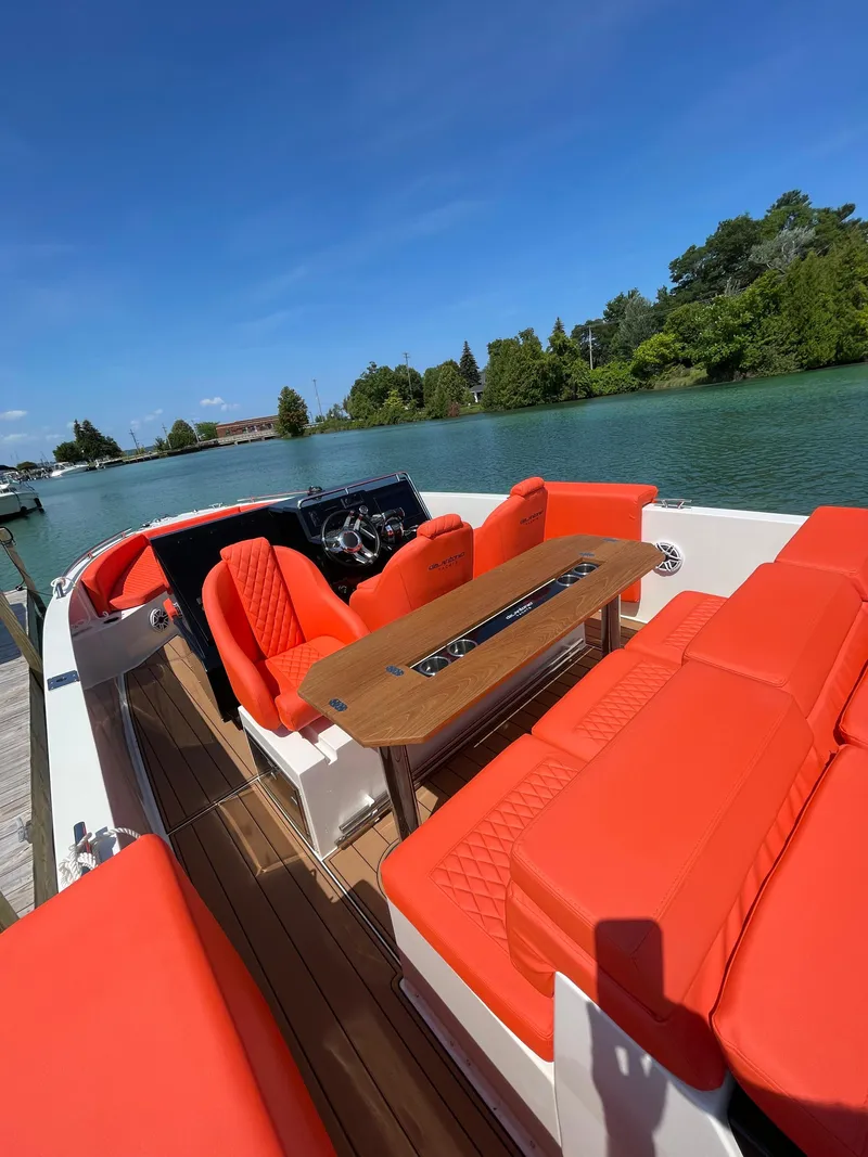 Slide: The Image of 2020 De Antonio Yachts D 28 with vibrant orange seating on a serene waterway. - 10