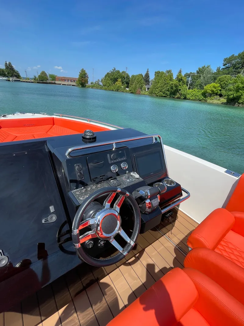 Slide: The Image of 2020 De Antonio Yachts D 28 helm with red seating on a serene lake. - 12