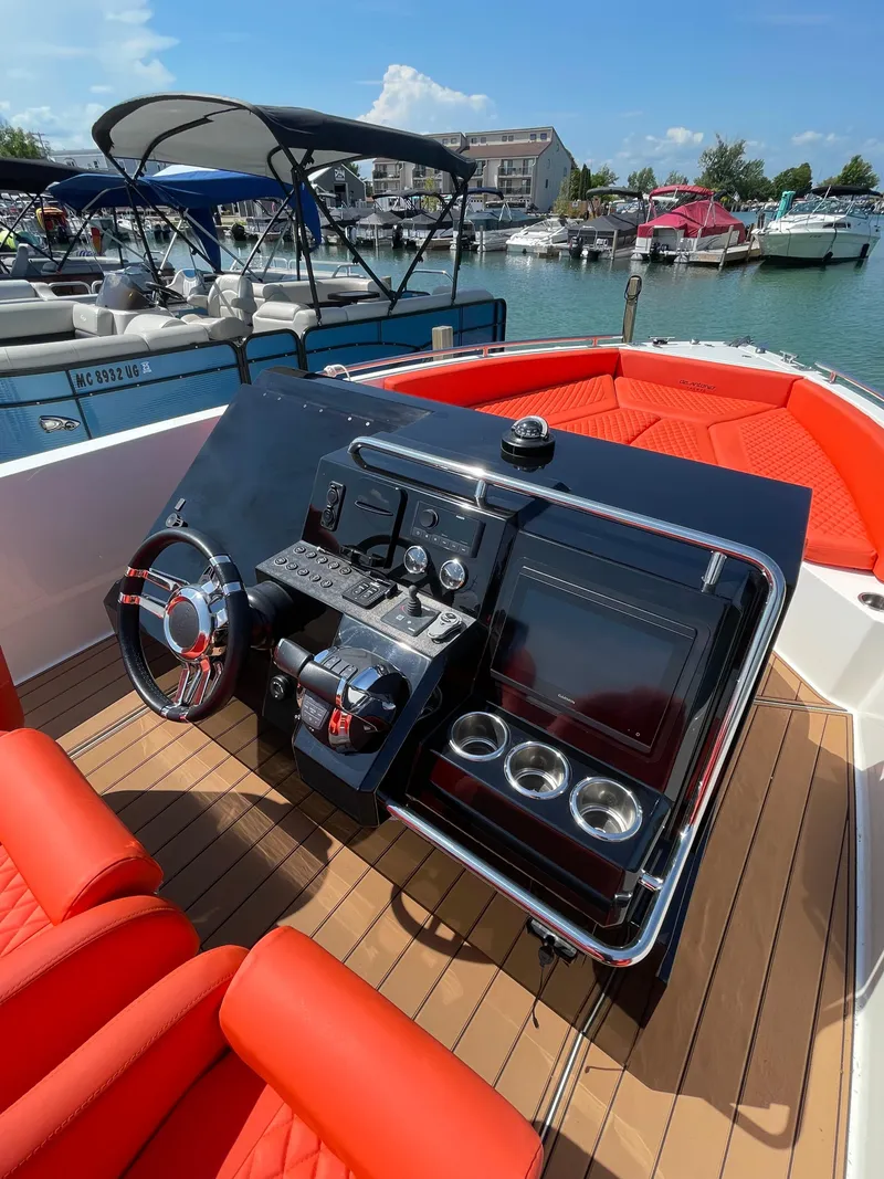 Slide: The Image of 2020 De Antonio Yachts D 28 boat dashboard with red seating, docked at marina. - 16