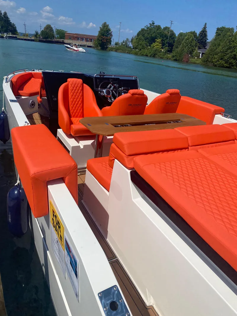 Slide: The Image of 2020 De Antonio Yachts D 28 with vibrant orange seating on a serene lake. - 20