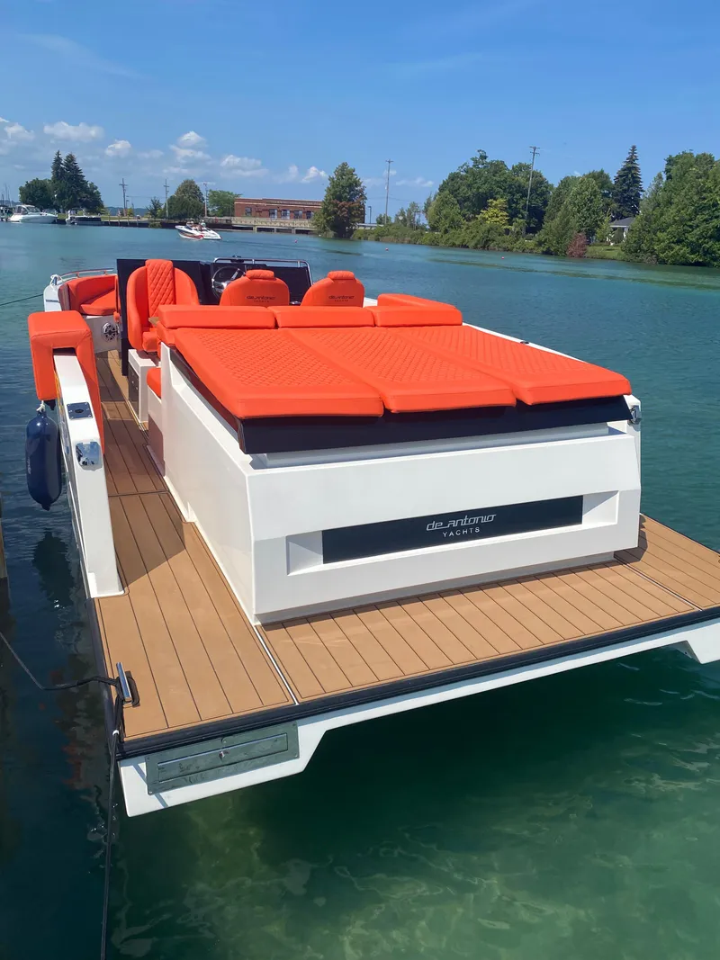 Slide: The Image of 2020 De Antonio Yachts D 28 with vibrant orange seating on a serene lake. - 21