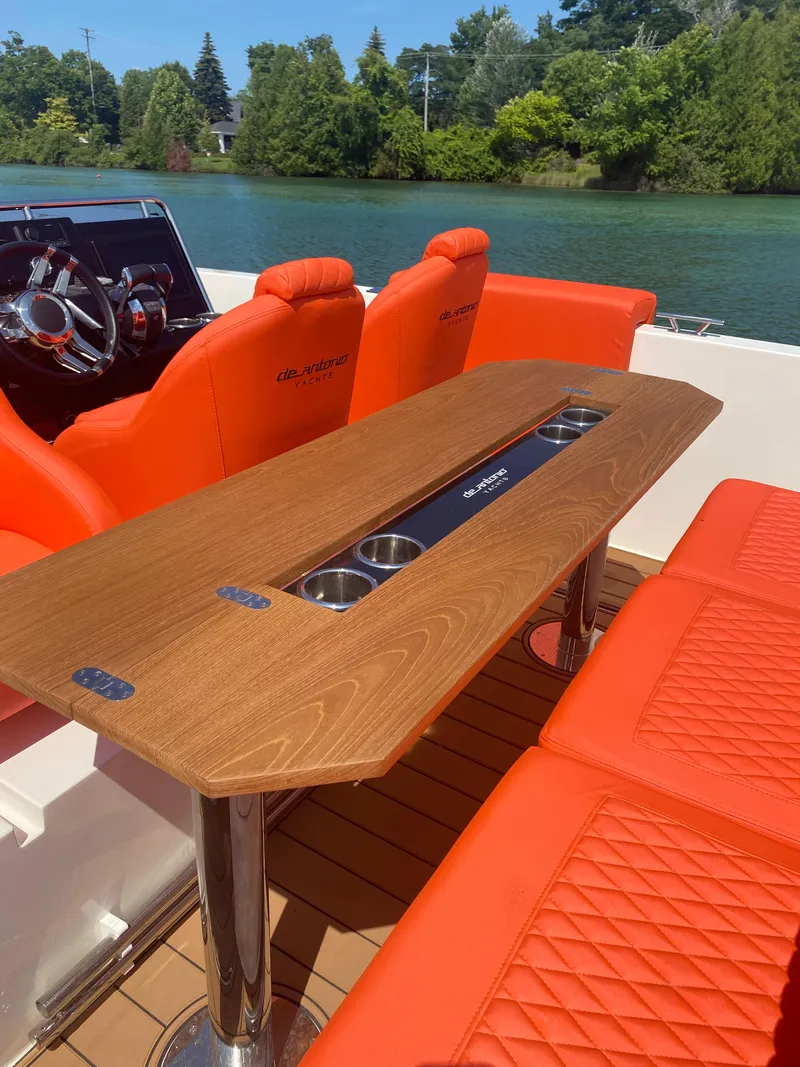 Slide: The Image of De Antonio Yachts D 28 2020 model with orange seating and wooden table on a serene lake. - 24
