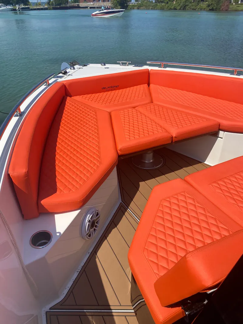 Slide: The Image of 2020 De Antonio Yachts D 28 with orange cushioned seating on deck. - 29