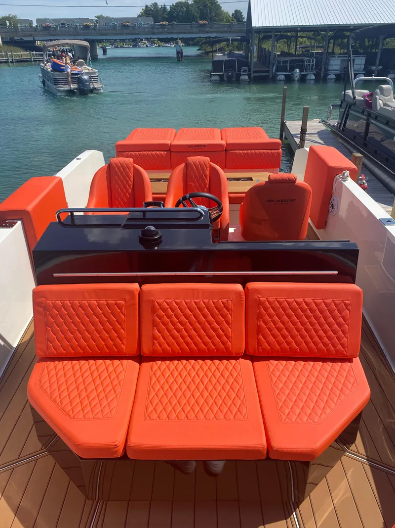 Slide: The Image of De Antonio Yachts D 28 2020 model with vibrant orange seating, docked at a marina. - 30