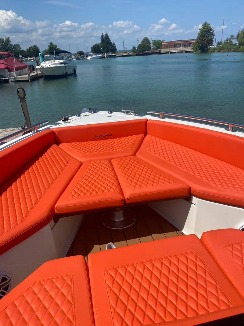 Slide: The Image of 2020 De Antonio Yachts D 28 with orange seating, docked by a serene lake. - 31