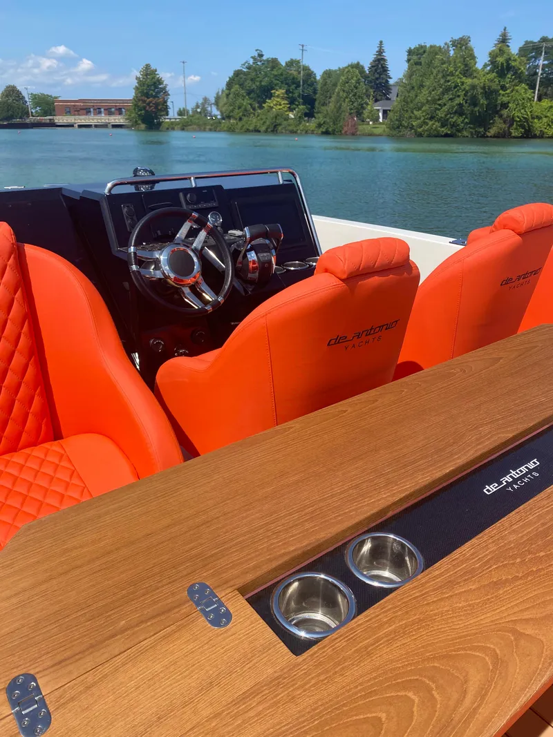 Slide: The Image of 2020 De Antonio Yachts D 28 with orange seats and wooden table on a serene lake. - 34