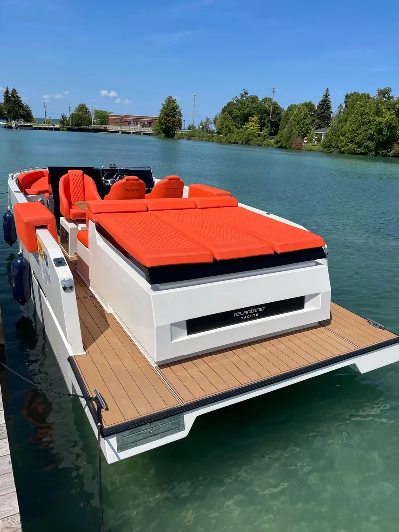 Slide: The Image of 2020 De Antonio Yachts D 28 with vibrant orange seating on a serene lake. - 5