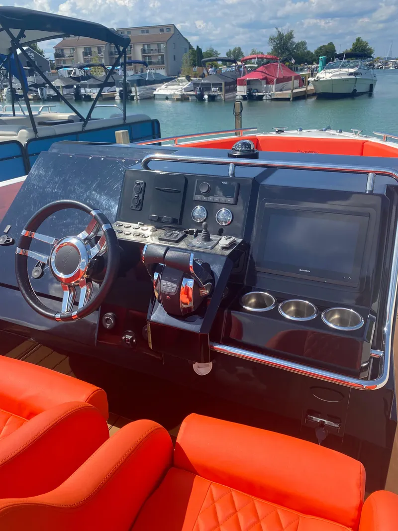 Slide: The Image of Helm of 2020 De Antonio Yachts D28 with modern controls and vibrant orange seating. - 51