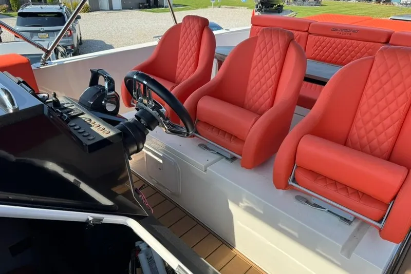 Slide: The Image of Red leather seats on 2020 De Antonio Yachts D28 boat, featuring modern steering controls. - 67