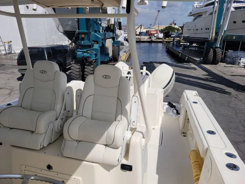Slide: The Image of 2002 Pursuit 3070 Center Console boat with white seating at a marina. - 11