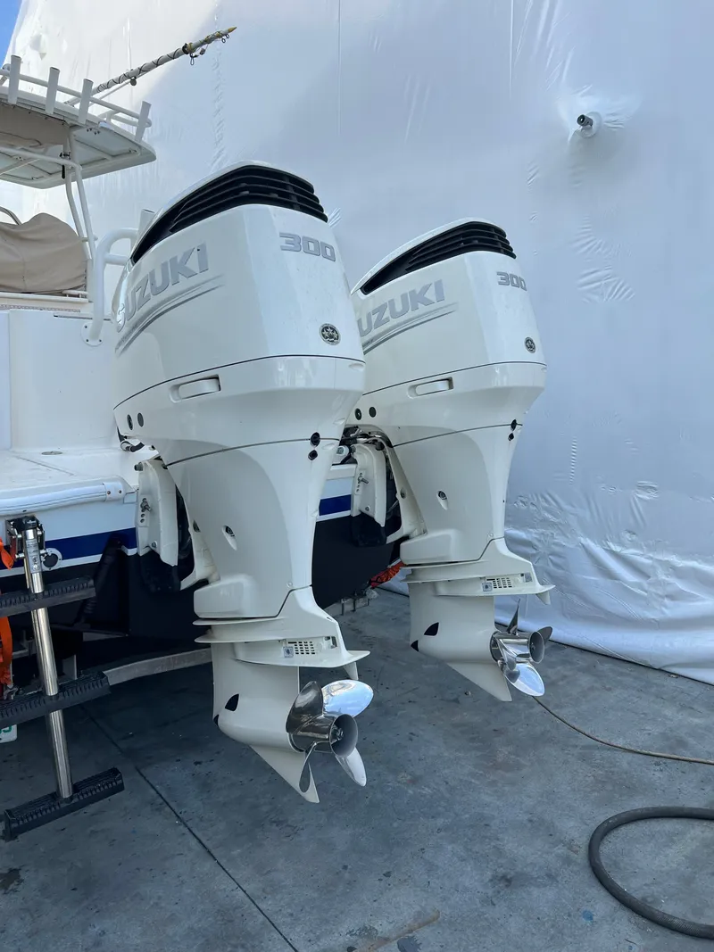 Slide: The Image of Twin Suzuki outboard motors on a 2002 Pursuit 3070 Center Console boat. - 12