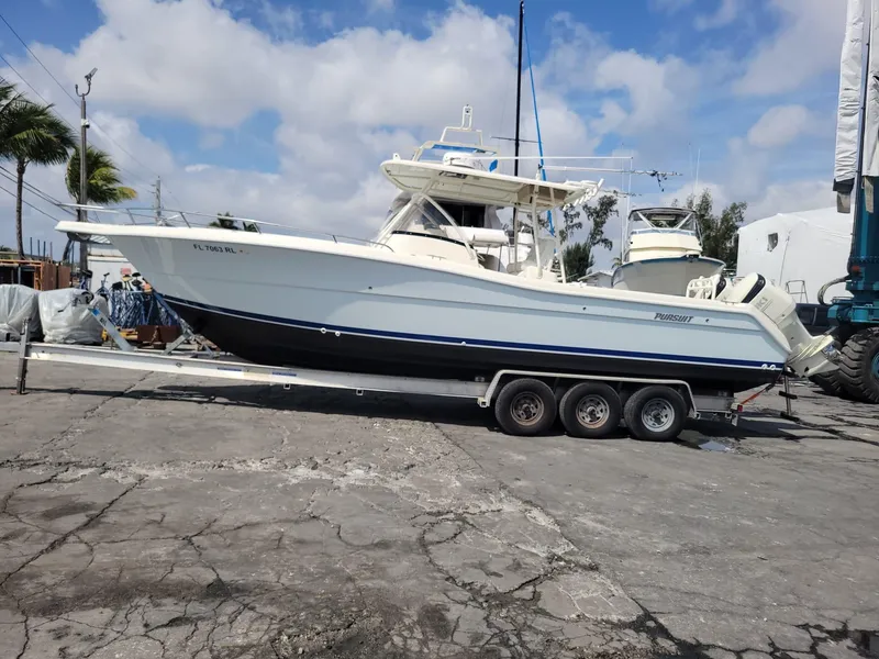 Slide: The Image of 2002 Pursuit 3070 Center Console boat on a trailer in a marina. - 7