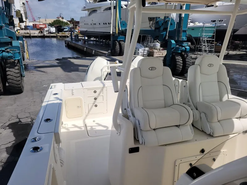 Slide: The Image of 2002 Pursuit 3070 Center Console boat with white seating at a marina. - 8