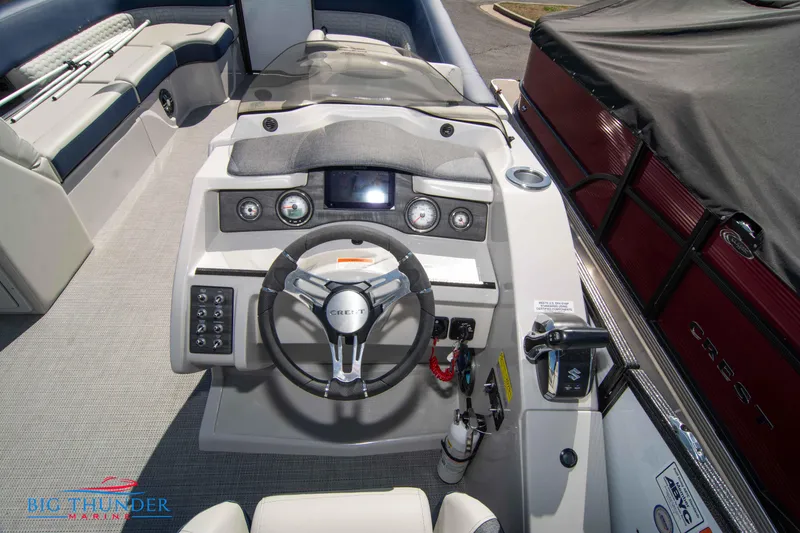 Slide: The Image of 2023 Crest Caribbean LX 250 SLC boat dashboard with steering wheel and control panel. - 11