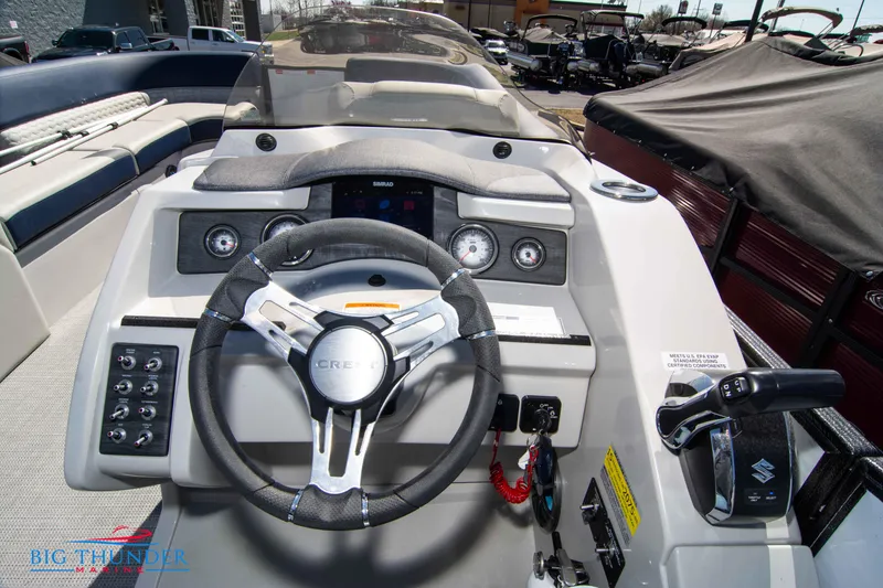 Slide: The Image of 2023 Crest Caribbean LX 250 SLC boat dashboard with steering wheel and controls. - 13