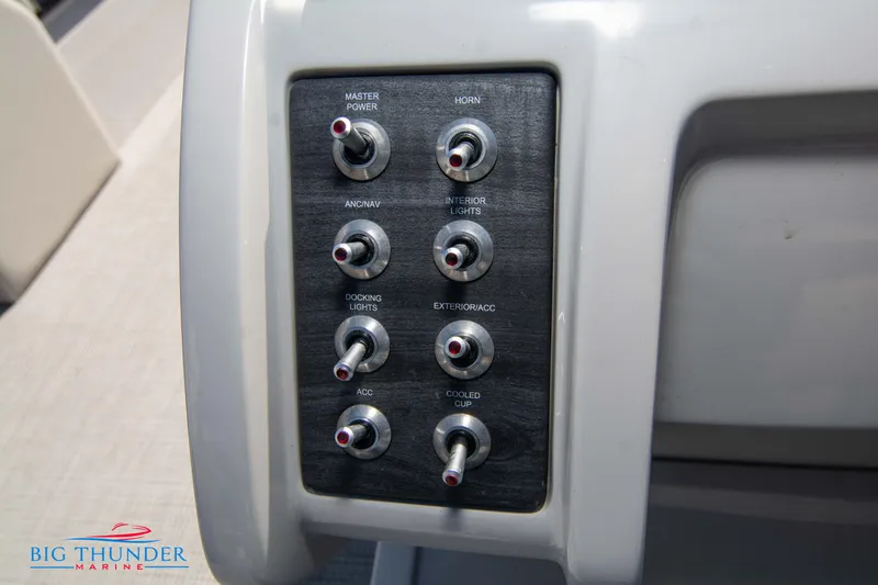 Slide: The Image of Control panel of 2023 Crest Caribbean LX 250 SLC boat with various switches. - 17