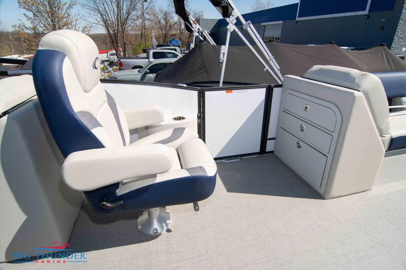 Slide: The Image of 2023 Crest Caribbean LX 250 SLC boat interior with captain's chair and storage drawers. - 24