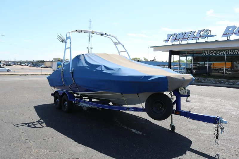 Slide: The Image of 2007 Tahoe Q6 SF boat on trailer with blue cover in dealership lot. - 14