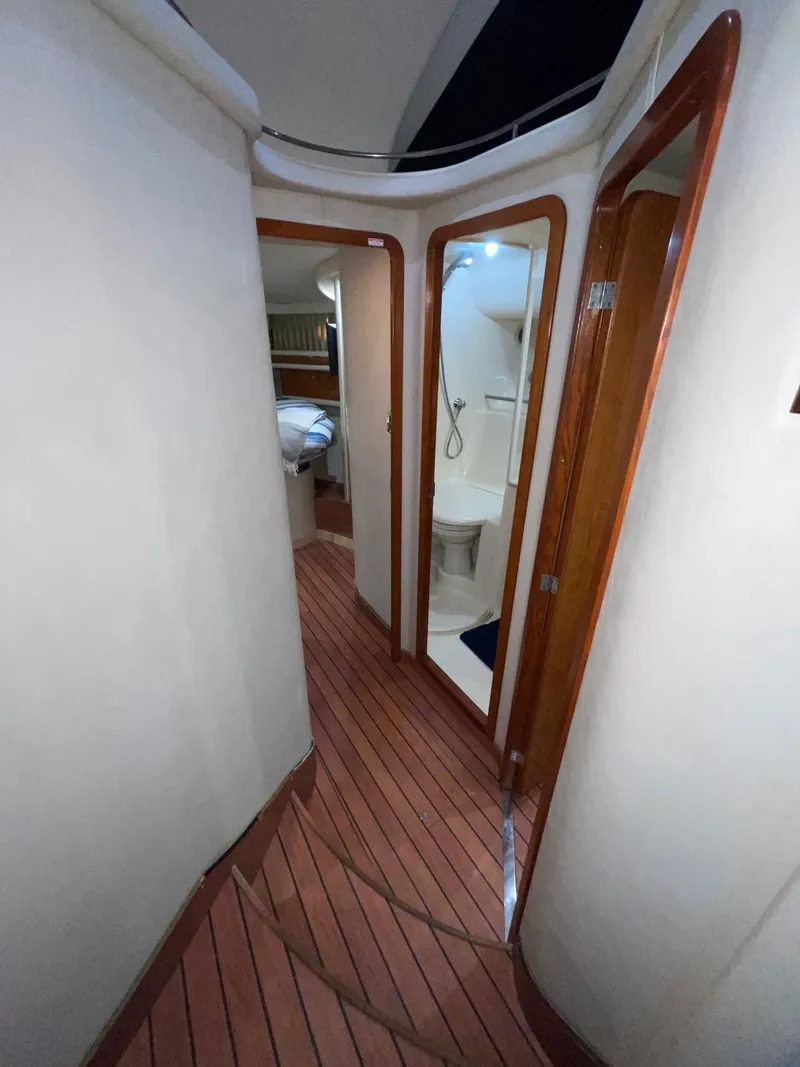 Slide: The Image of Alt text: Interior hallway of 2000 Sea Ray 450 Express Bridge yacht with wooden flooring and bathroom. - 17