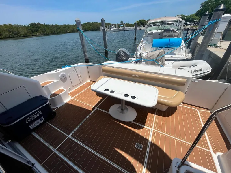 Slide: The Image of 2000 Sea Ray 450 Express Bridge boat deck with seating and table, docked at marina. - 28