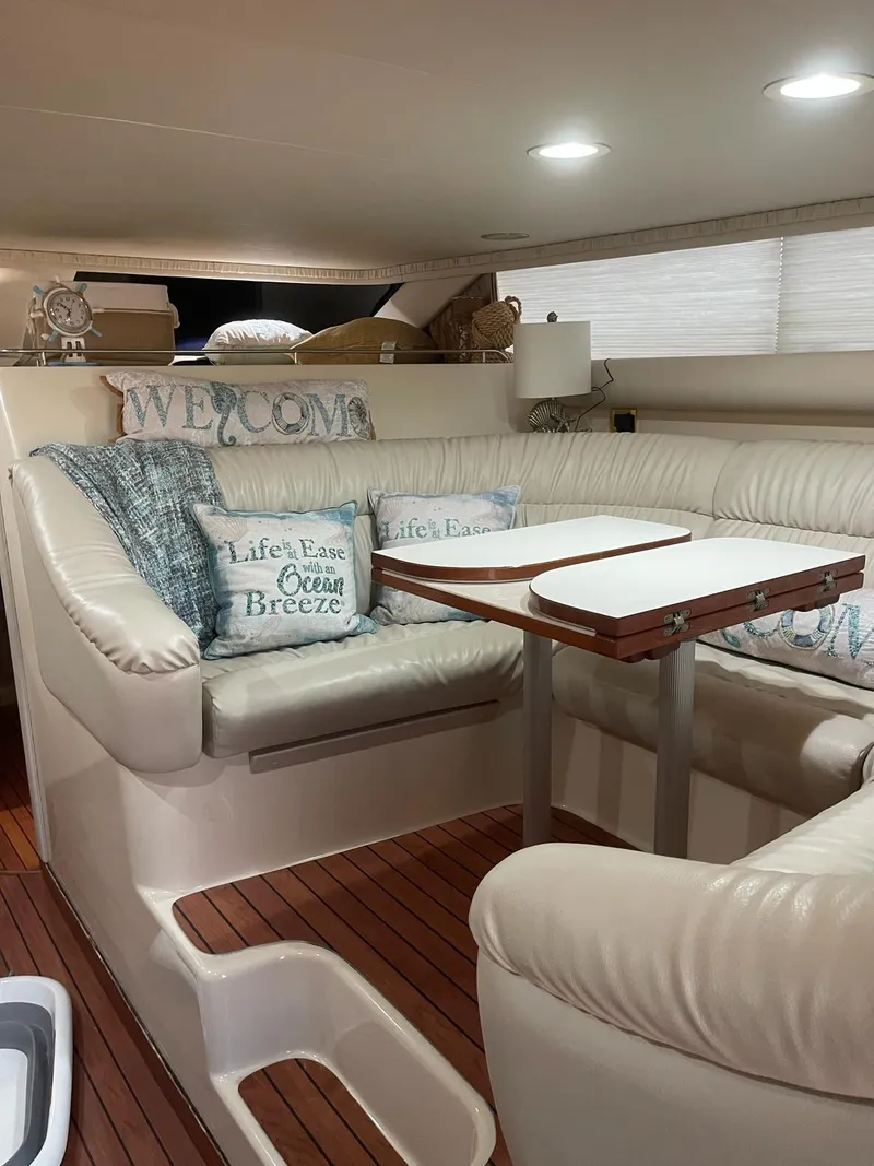 Slide: The Image of Luxurious interior of 2000 Sea Ray 450 Express Bridge with cozy seating and nautical decor. - 7
