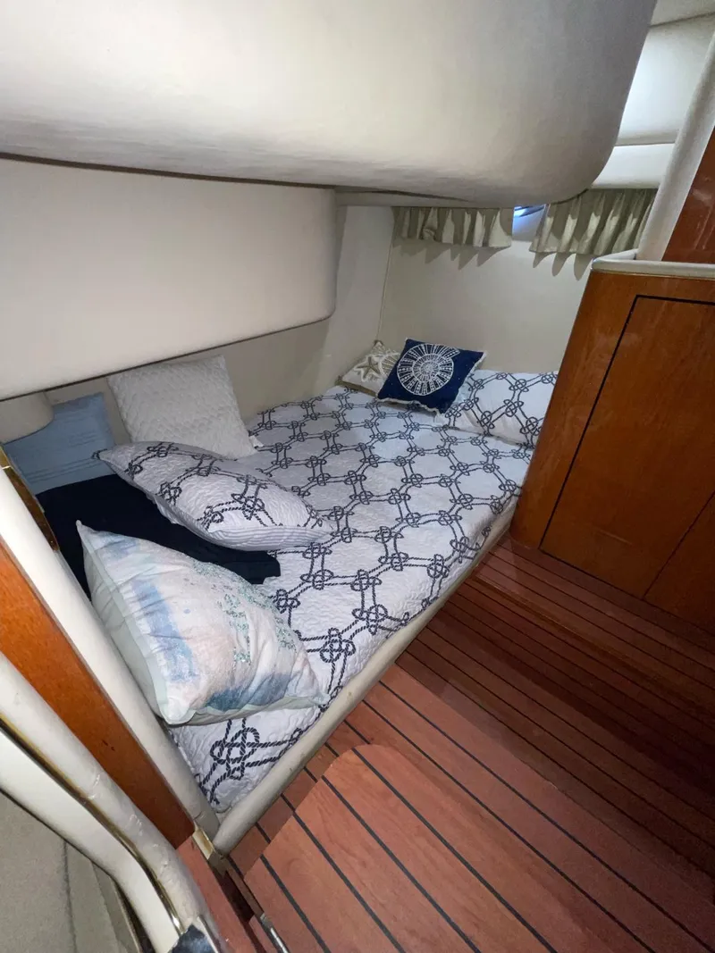 Slide: The Image of Cozy cabin interior of a 2000 Sea Ray 450 Express Bridge with nautical-themed bedding. - 8