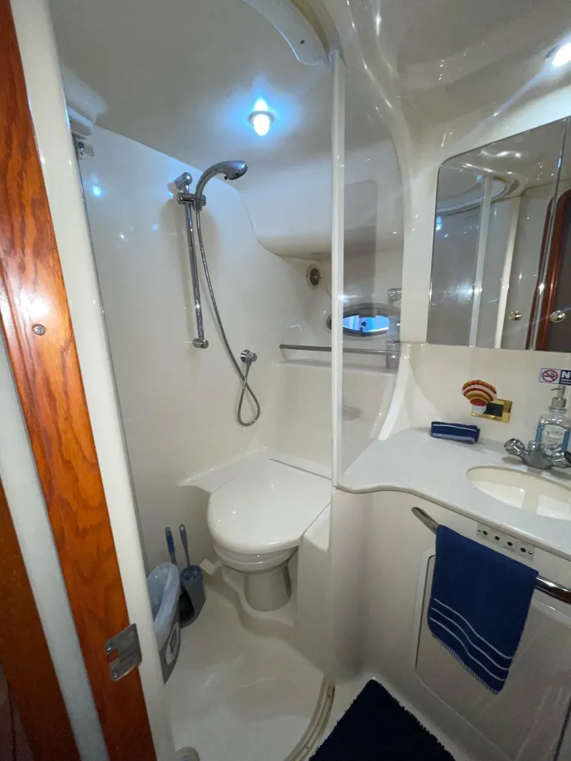 Slide: The Image of 2000 Sea Ray 450 Express Bridge bathroom with shower, sink, and toilet. - 9